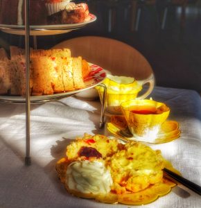 image of afternoon tea stand with sandwiches, tea, scones and cake